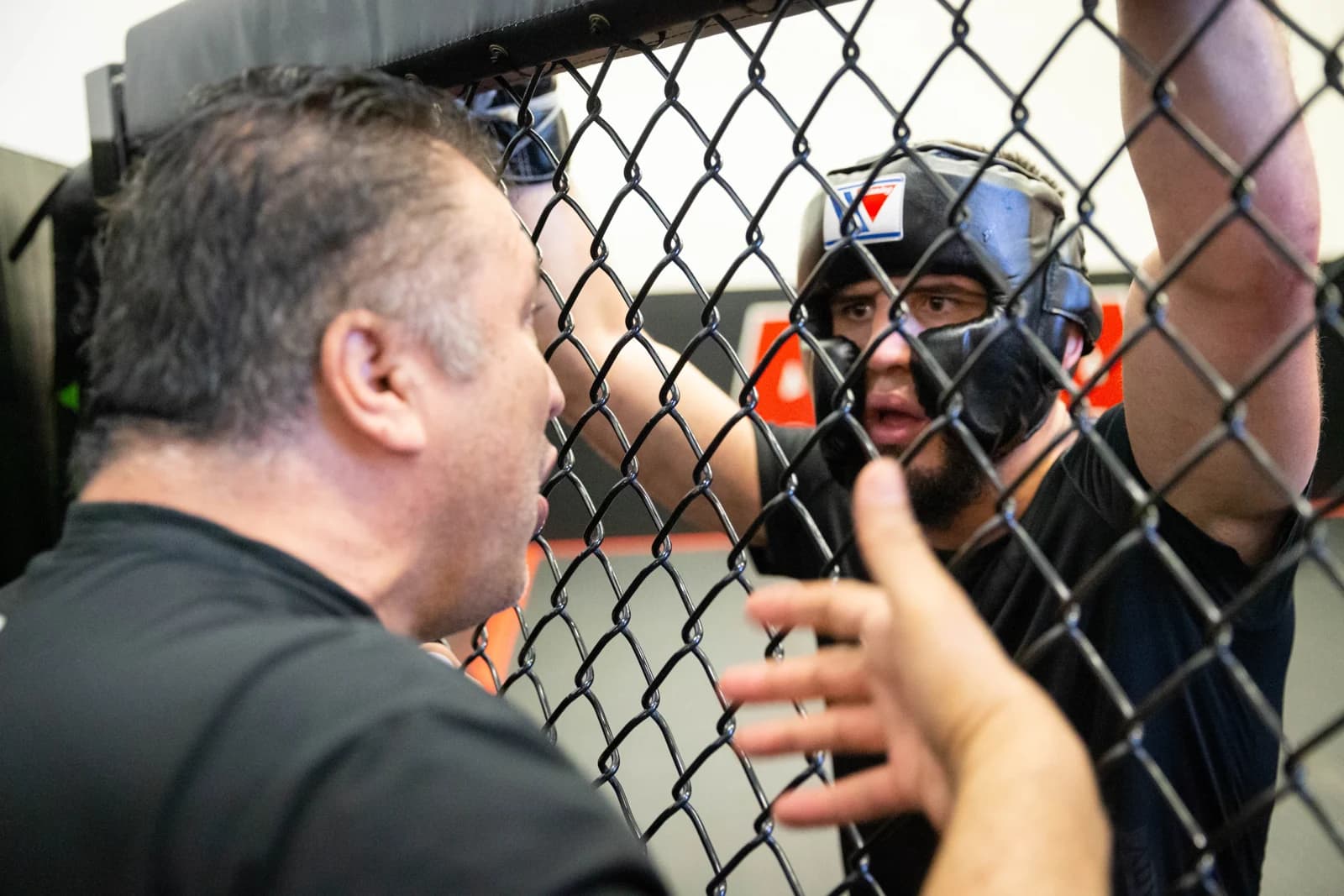 Islam Makhachev listening to Javier Mendez through the training cage